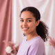 A young woman smiling, with a soft, approachable expression, conveying happiness and trust.